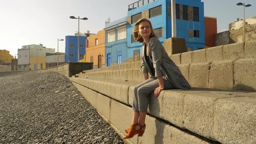 Stylish Woman Relaxing by Colorful Coastal City