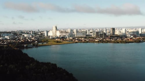 Hermoso panorama aéreo del tranquilo lago de otoño, paisaje moderno futurista del horizonte de la ciudad y el bosque