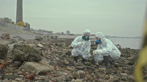 Scientists in Protective Suits Collect Samples Near Water