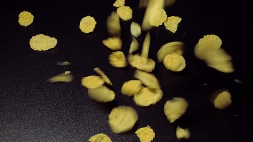 Fallende Cornflakes auf schwarzem Hintergrund