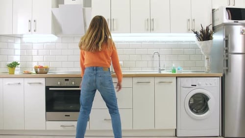 Young Woman Dances Energetically in Her Kitchen