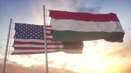 United States and Hungary Flags Waving at Sunset