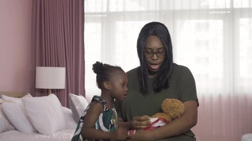 Loving Mother and Daughter Play with Teddy Bear