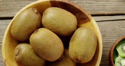 In Scheiben geschnittene und geschälte Kiwi auf Holztisch