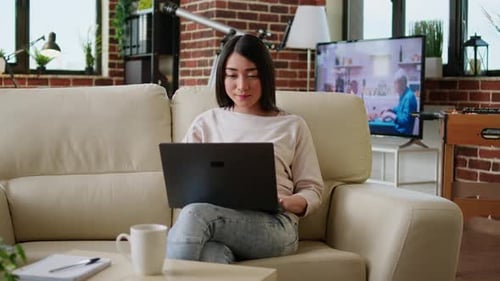 Woman Using Laptop on Couch Indoors