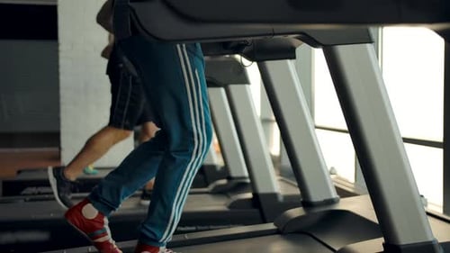 Three People Running on Treadmills in a Gym Side Viewv