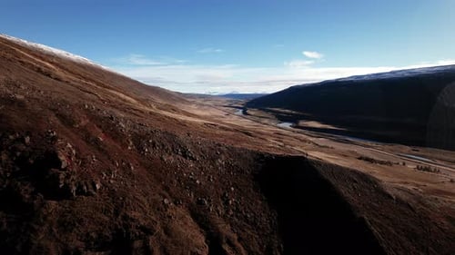 Drone Over Dramatic Icelandic Landscape of Hillsides and River