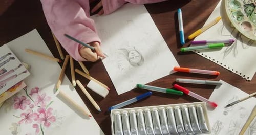 Young Woman Artist Hands Painting Man Portrait on White Paper Using a Pencil Closeup
