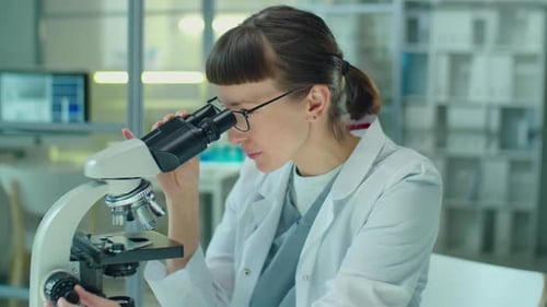 Female Scientist Using Microscope in Laboratory