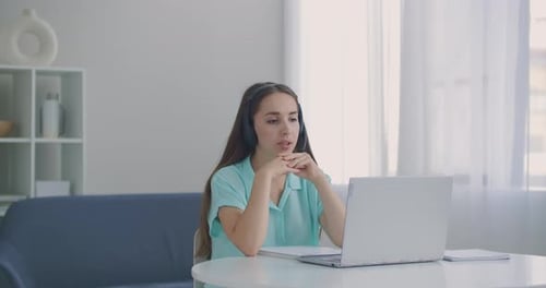 Woman in Headset on Video Call at Home