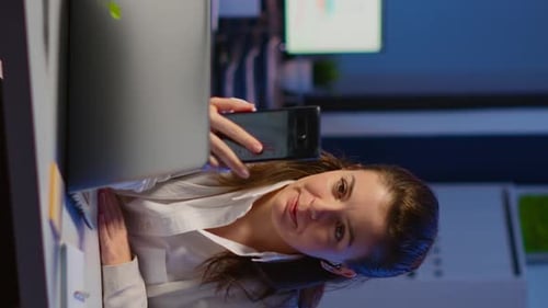 Woman Video Conferencing at Desk in Office at Night