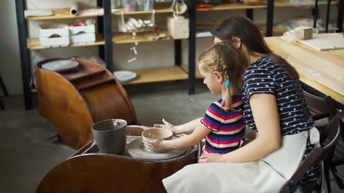 Woman and Child Working Together at Pottery Wheel