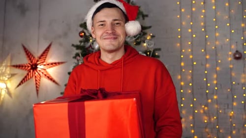 Man Smiles Holding Christmas Present in Festive Setting