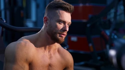 Muscular man in gym. Fit and sporty bodybuilder man in gym