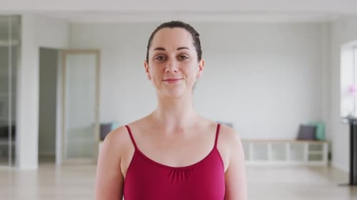 Caucasian female ballet dancer smiling and looking at camera