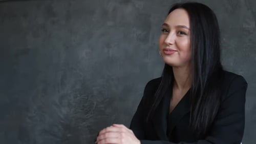 Woman Talking Indoors in Black Blazer