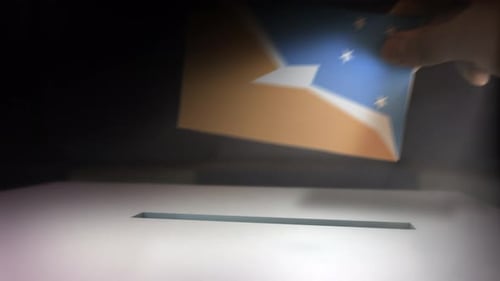 Hand Inserts Vote Ballot into Election Box