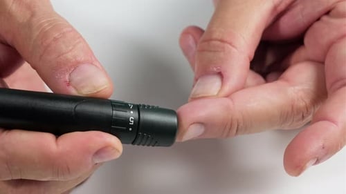 Finger Prick with a Lancing Device Close Up