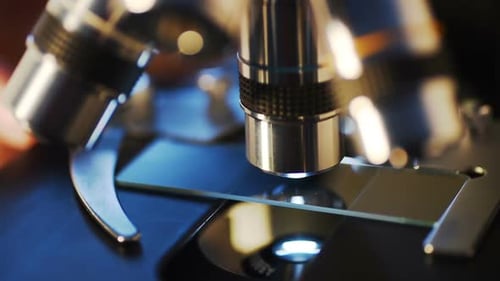 Close Up of Microscope Adjusting Sample Slide