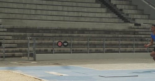 Vista de cerca de un atleta de raza mixta haciendo salto de longitud