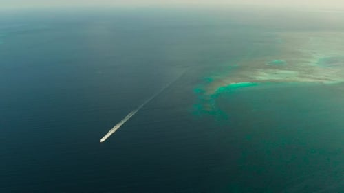 Seascape, Coral Reef and Blue Sea with Motorboat. Balabac, Palawan, Philippines.