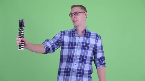 Man Holding Cell Phone with Tripod on Green Screen