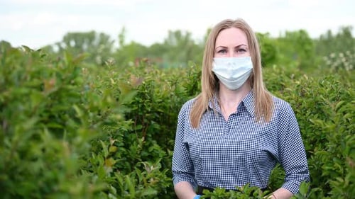 Woman Wearing Face Mask Standing in a Field