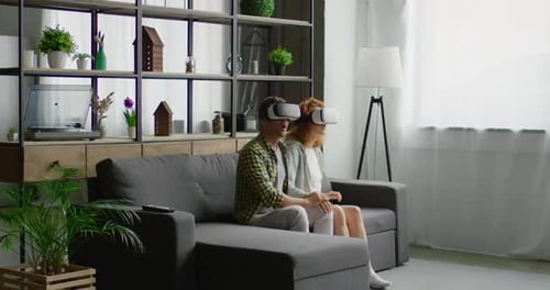 Couple Experiencing Virtual Reality Headsets at Home