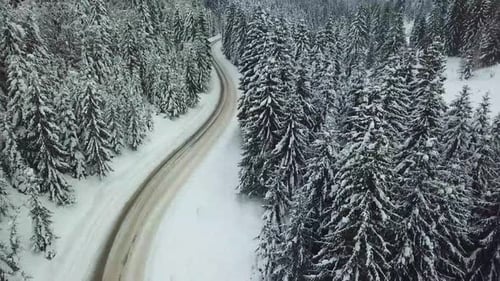 Aerial drone view of road in idyllic winter landscape.