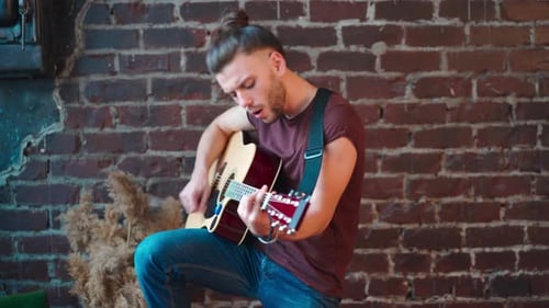 Young Adult Playing Acoustic Guitar and Singing