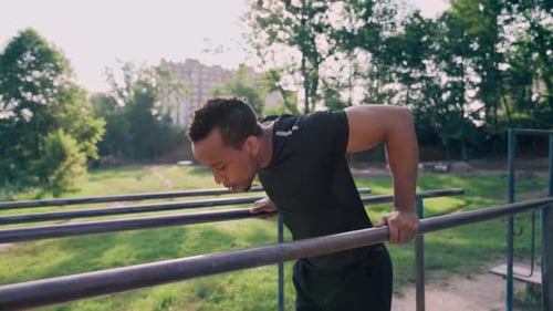 Man Doing Dips Outdoors on Parallel Bars