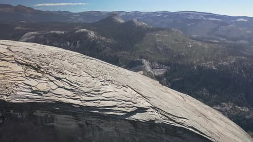 Aerial Footage of the Top of Half Dome Mountain Against the Background of Sierra Nevada Range