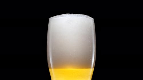 Beer Pouring into Glass with Foam Head