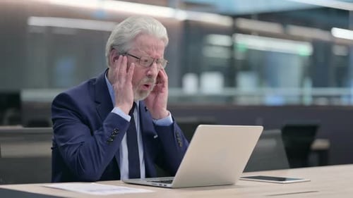 Shocked Businessman Looking at Computer in Office
