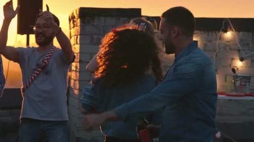 Friends Dancing on Rooftop at Sunset Party