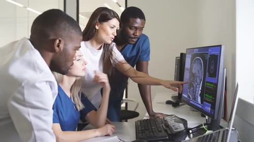 Team of Radiologists Looking at Patient CT Scan Image at Display Discussing Treatment of Patient