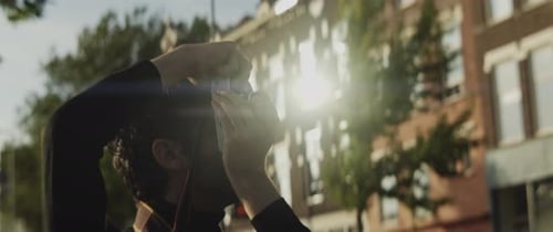 Young Adult Taking Photograph in City Street