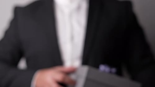 Person Holding Gray Gift Box with Purple Bow