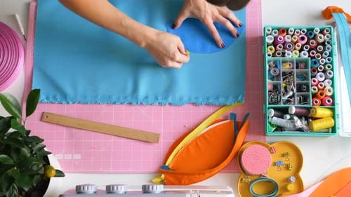 Näherin zeichnet Schnittmuster einer Kosmetiktasche auf Stoff