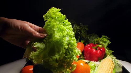 Fresh Vegetables Being Washed on Dark Background