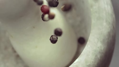 Colorful Peppercorns Falling Into Stone Mortar, Close Up