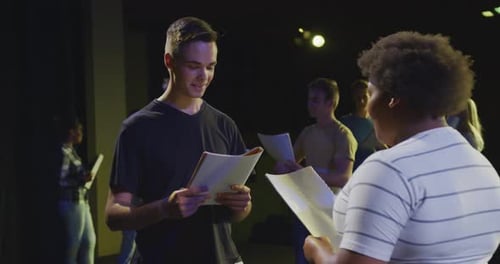 Students preparing before a high school performance in an empty school theater