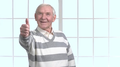 Hombre mayor con el signo del pulgar hacia arriba.