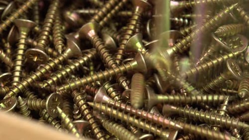 Close up of Screws Falling into Large Pile