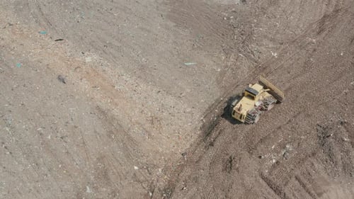 City Dump. The Bulldozer Moves Along the Landfill, Leveling the Garbage.