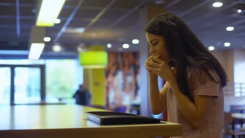 Young Lady Eating Burger Sitting Cafe Table, Junk Food Addiction, Unhealthy Meal