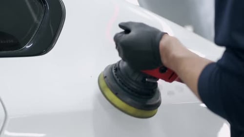 Man Polish a Car in a Garage