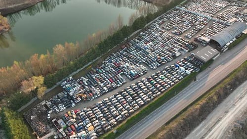 Luftaufnahme des großen Parkplatzes des Schrottplatzes mit Reihen von weggeworfenen kaputten Autos