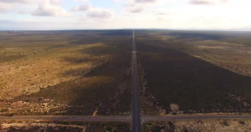Aerial view of a dirt road winding around rural field