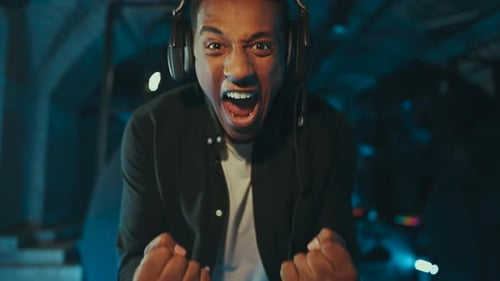 Excited Gamer Celebrating Victory in a Blue Lit Room